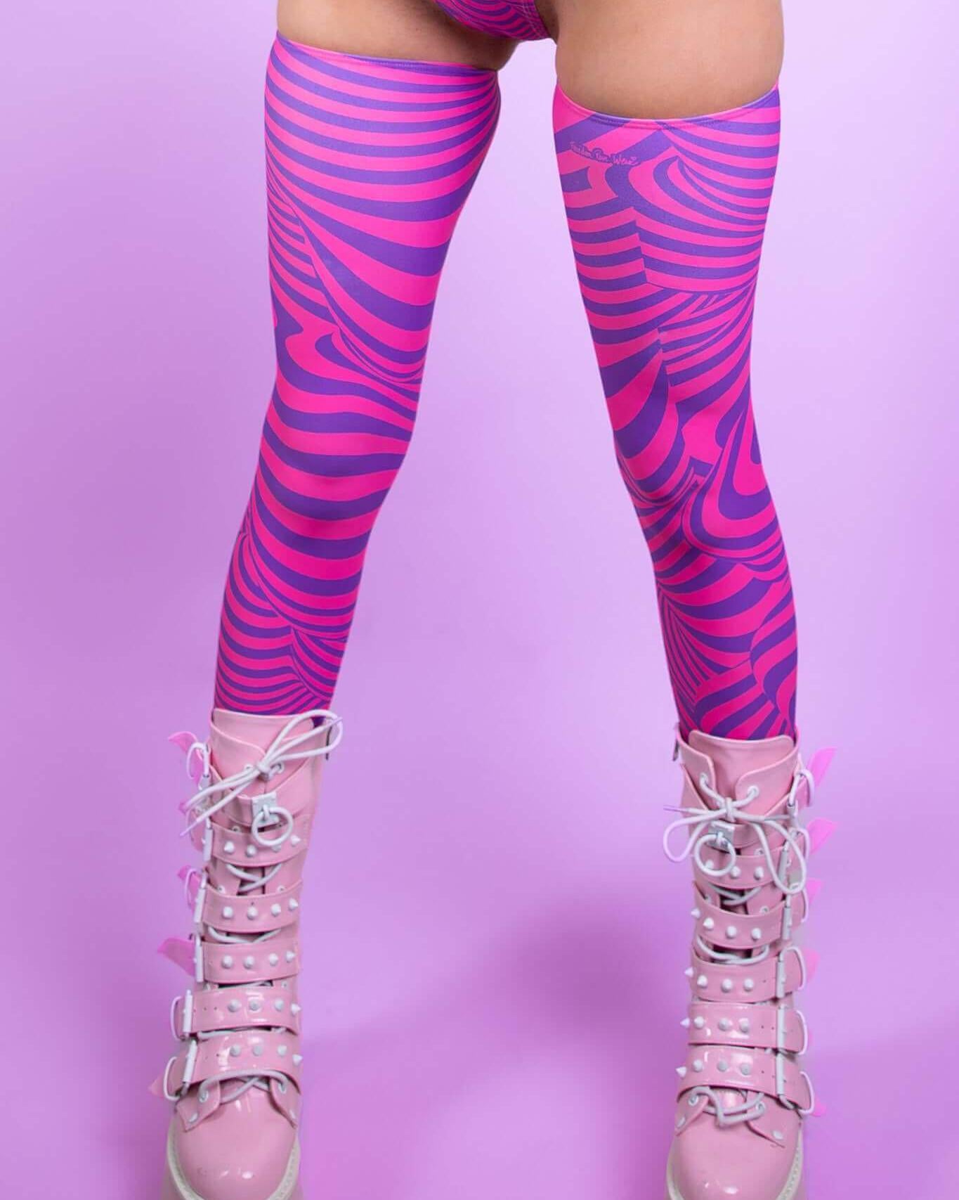 Cheshire Leg Sleeves in bold pink and purple stripes, paired with stylish lace-up boots, perfect for rave outfits.