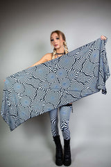 A woman holding up a black and white geometric printed pashmina.