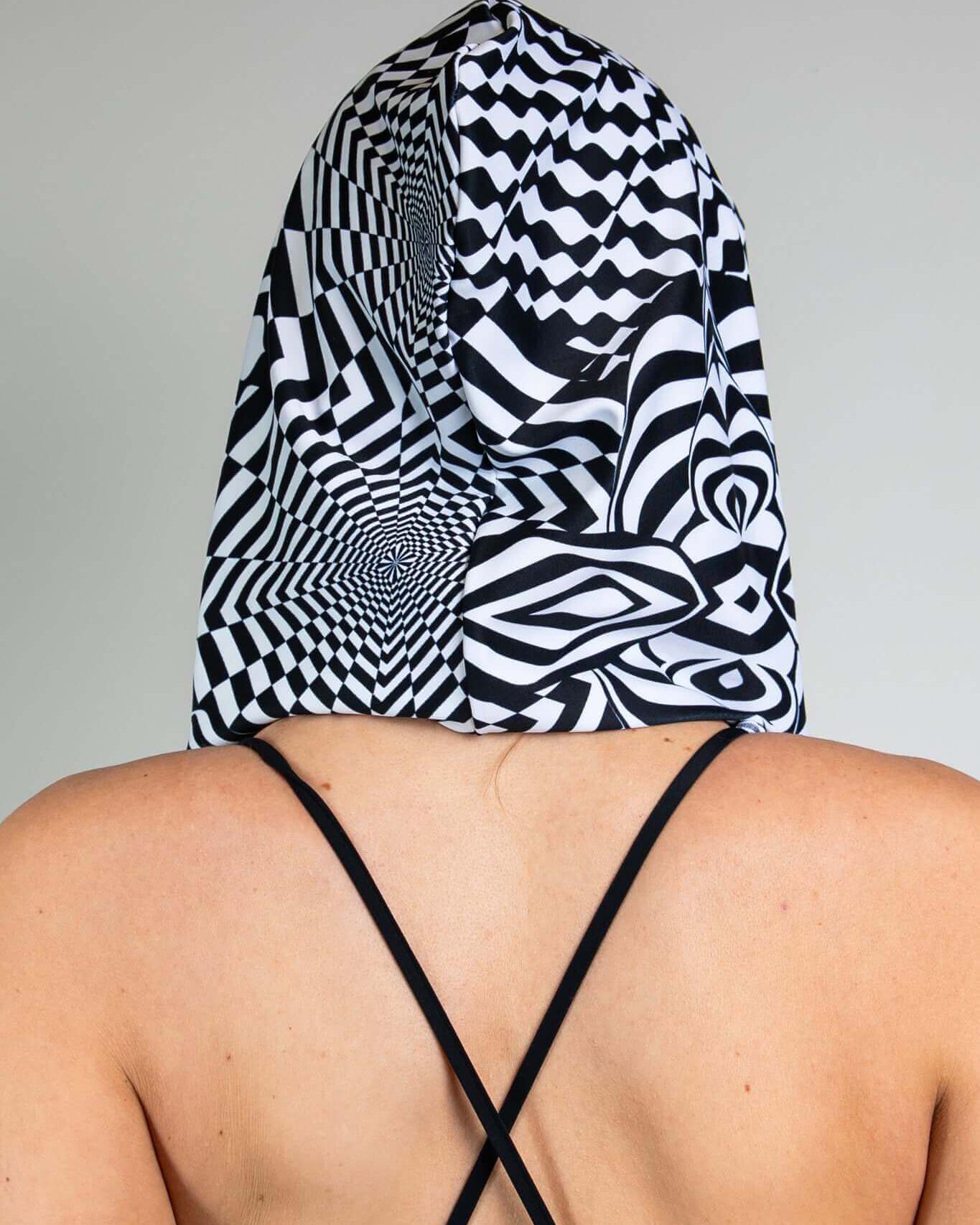 Distortion Assassin Hood featuring abstract optical labyrinth design, perfect for rave outfits and parties.