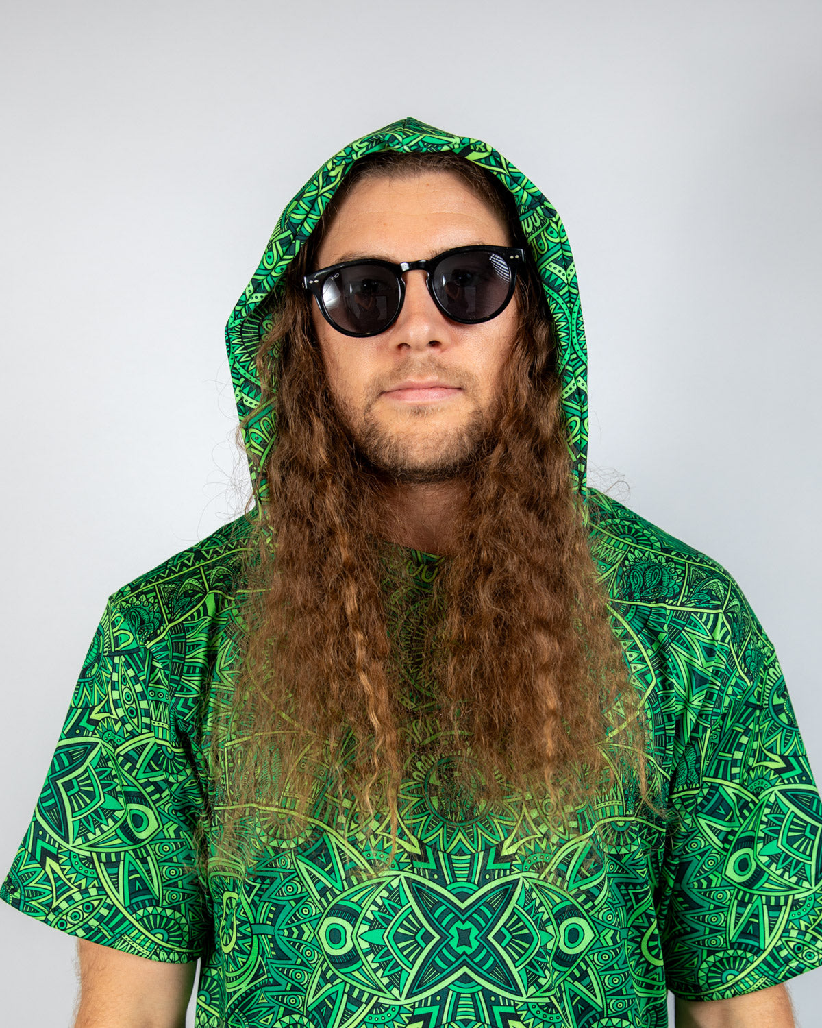 Model wearing a green Dominion Assassin Hood and sunglasses, showcasing a vibrant rave outfit.