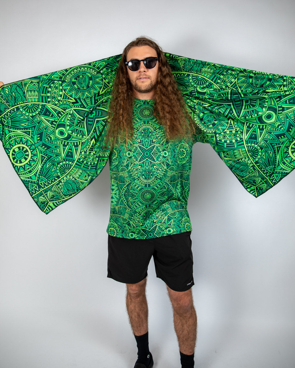 Bold green oversized Festival Scarf worn by a man with long hair and sunglasses, showcasing psychedelic patterns.