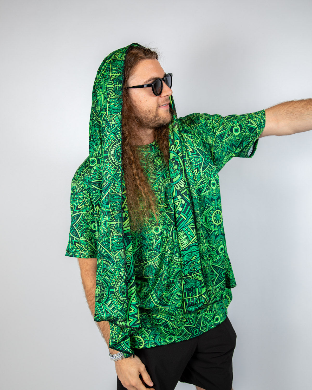 Man wearing a green psychedelic patterned oversized scarf and matching shirt, perfect for festival vibes.