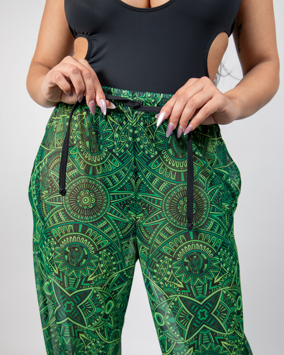 Close-up of the waist and drawstring of Dominion Mesh Lucy Pants featuring neon green tribal print design.