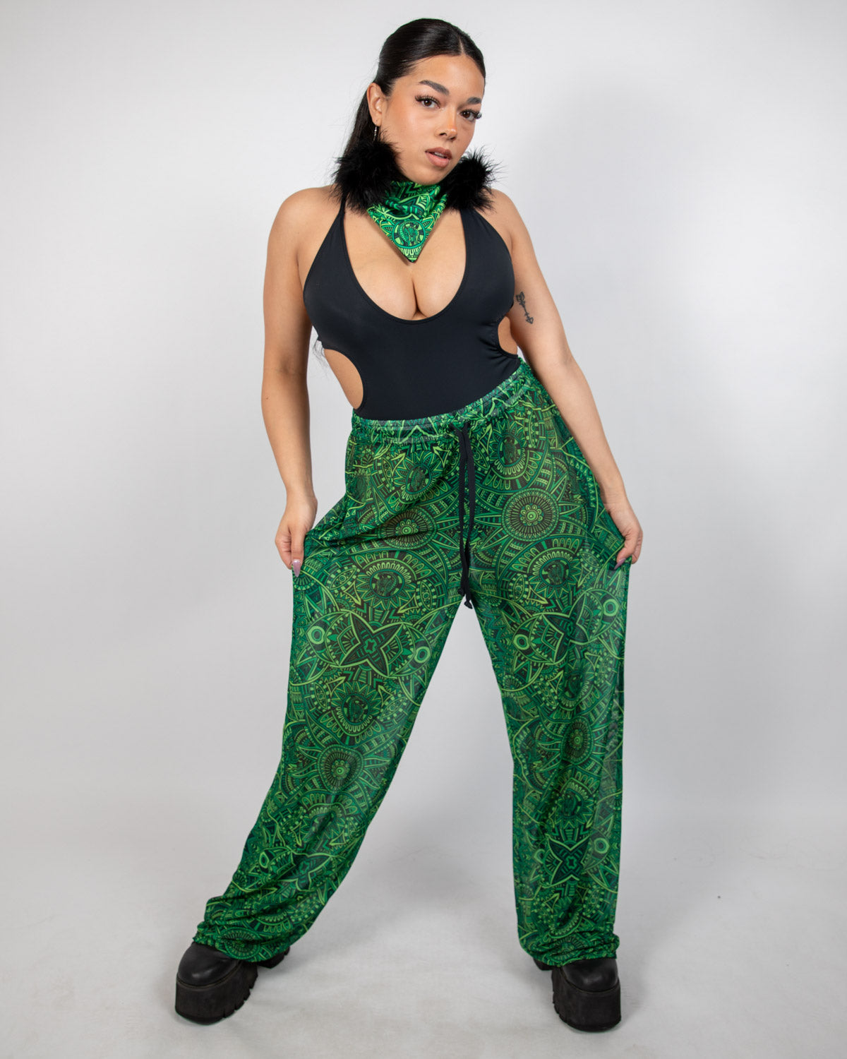 Model showcasing Dominion Mesh Lucy Pants with neon green tribal design, perfect rave bottoms for style and comfort.