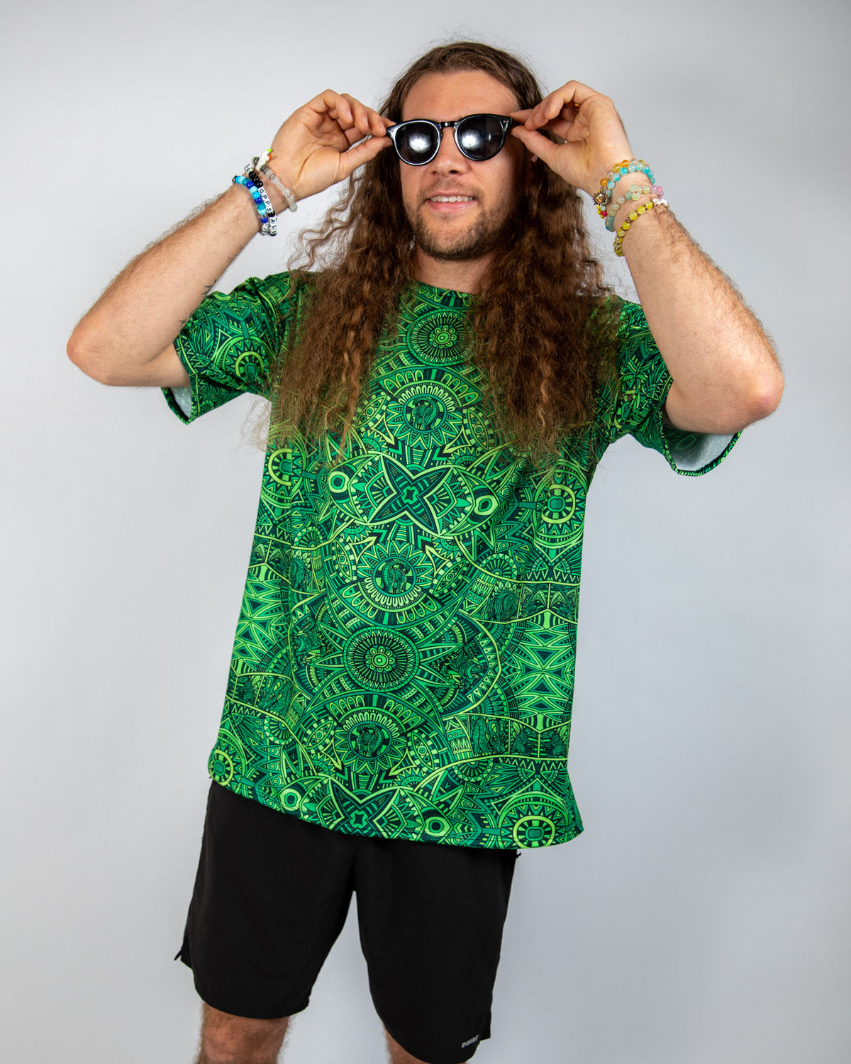 Man wearing the Dominion Oversized Softee Rave T-Shirt with psychedelic pattern and sunglasses.