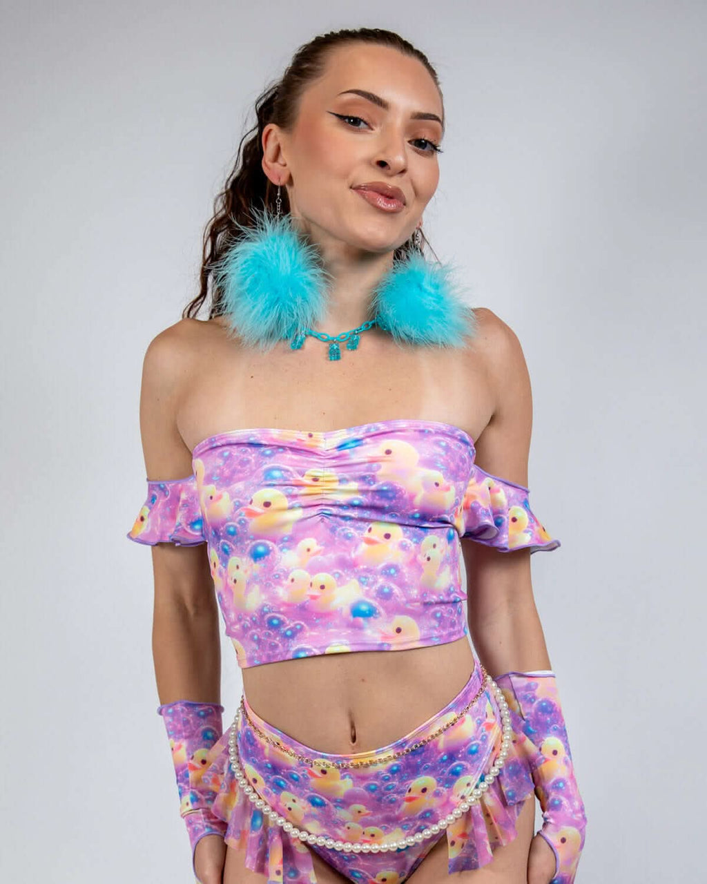 Woman wearing Duckies Bardot Top, a vibrant off-shoulder rave outfit in purple, yellow, and pink colors.