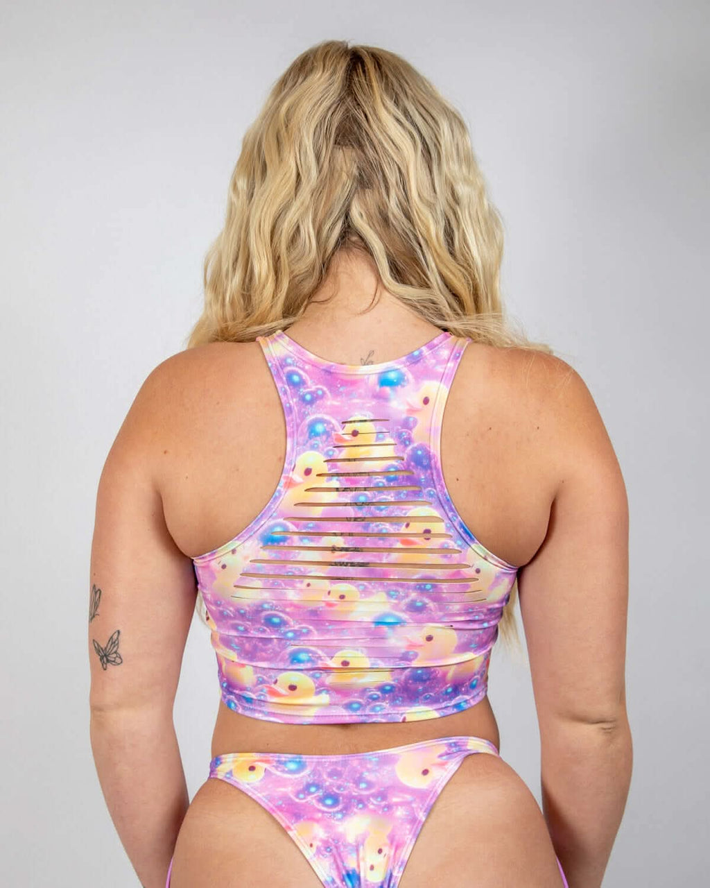 View of the back of the Duckies Slit Crop Top featuring a playful purple and pink color print, perfect for rave outfits.