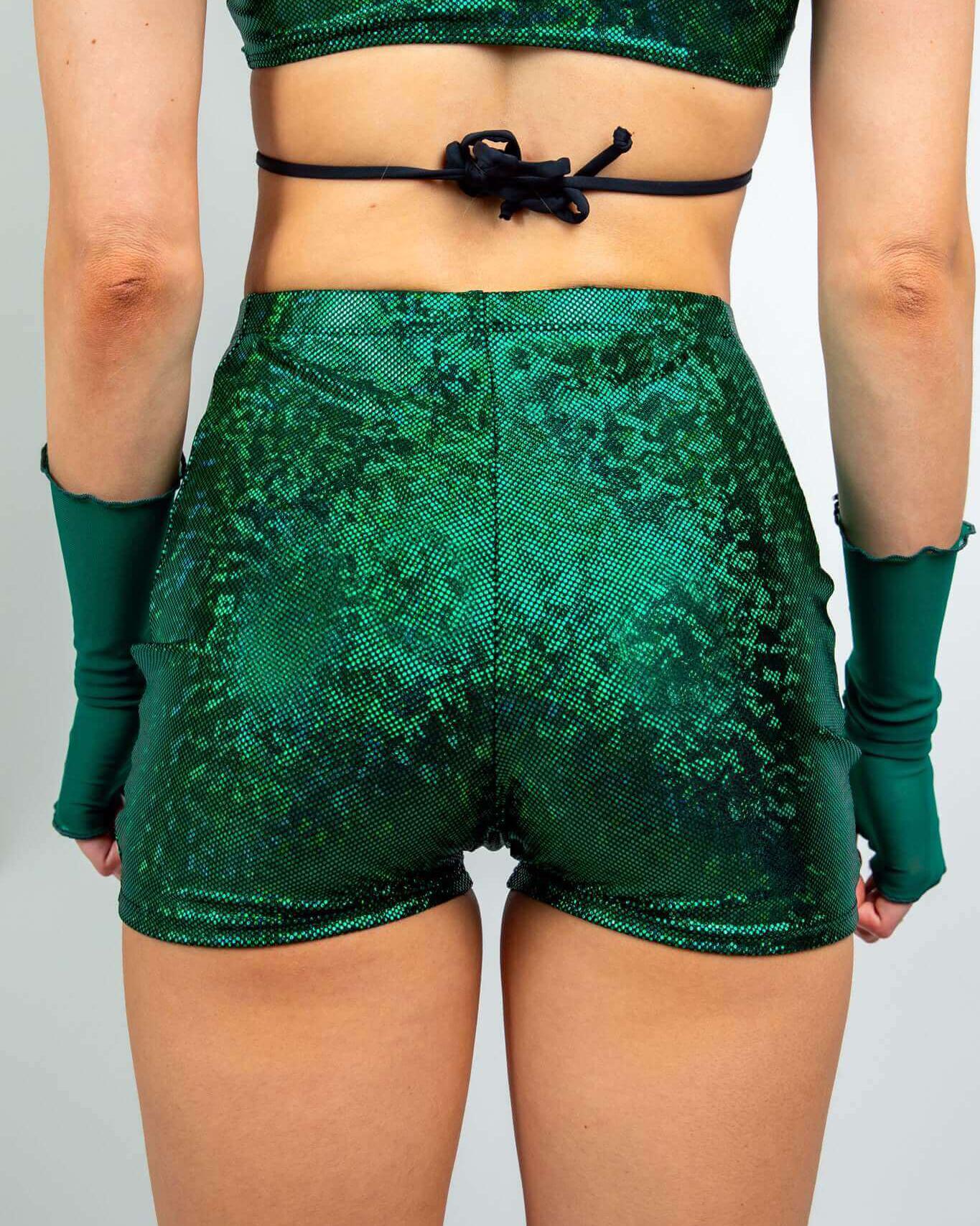 Model wearing emerald holographic high waist shorts, showcasing the seamless design and vibrant green color ideal for rave outfits.