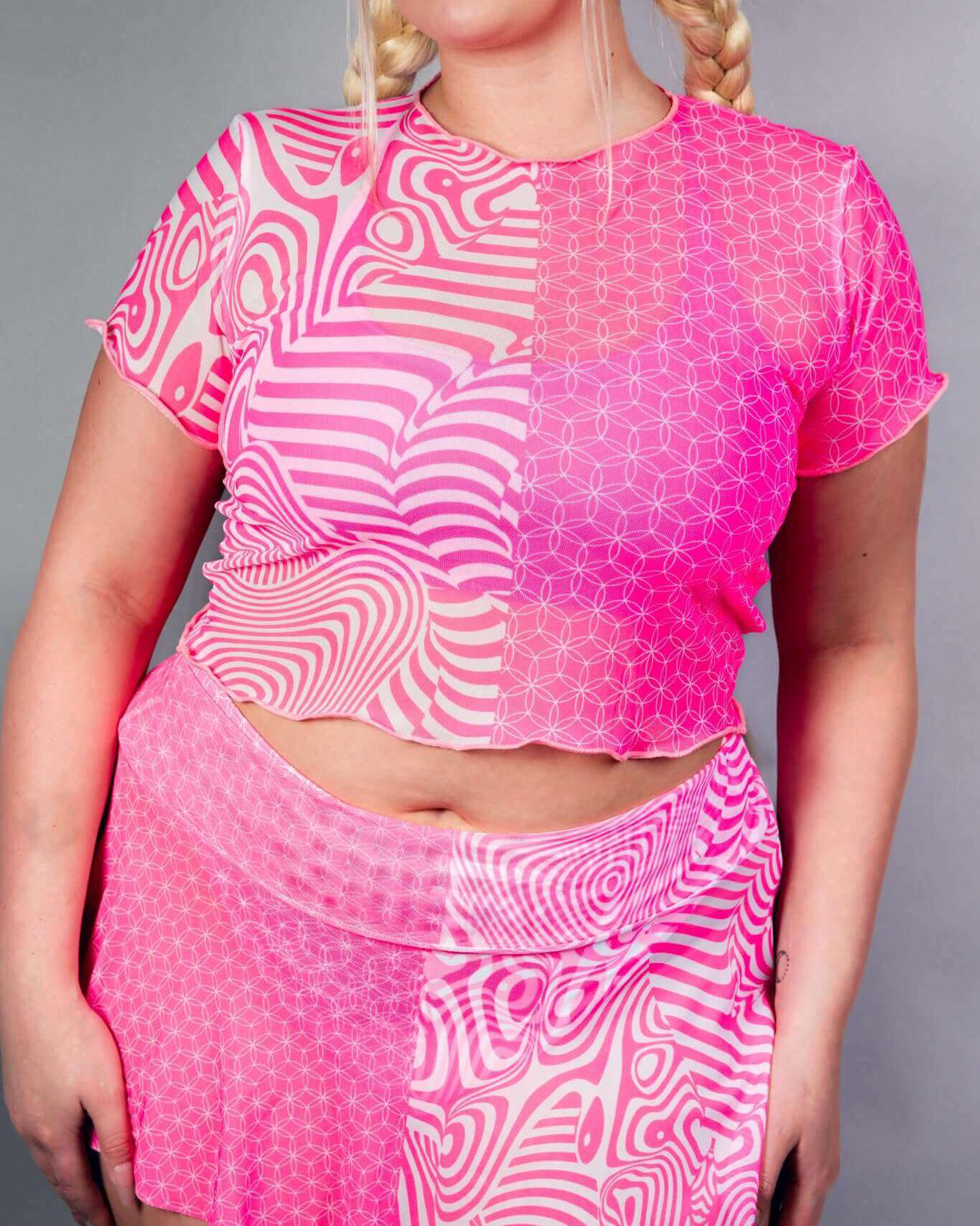 Vibrant neon pink mesh baby tee with abstract patterns, perfect for rave outfits and stylish layered looks.