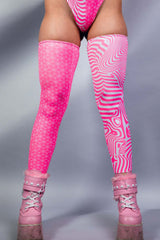 A photo of a woman's legs wearing pink and white leg sleeves that go up to her upper thigh.