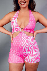 A woman wearing a pink and white halter top romper with an o-ring detail.