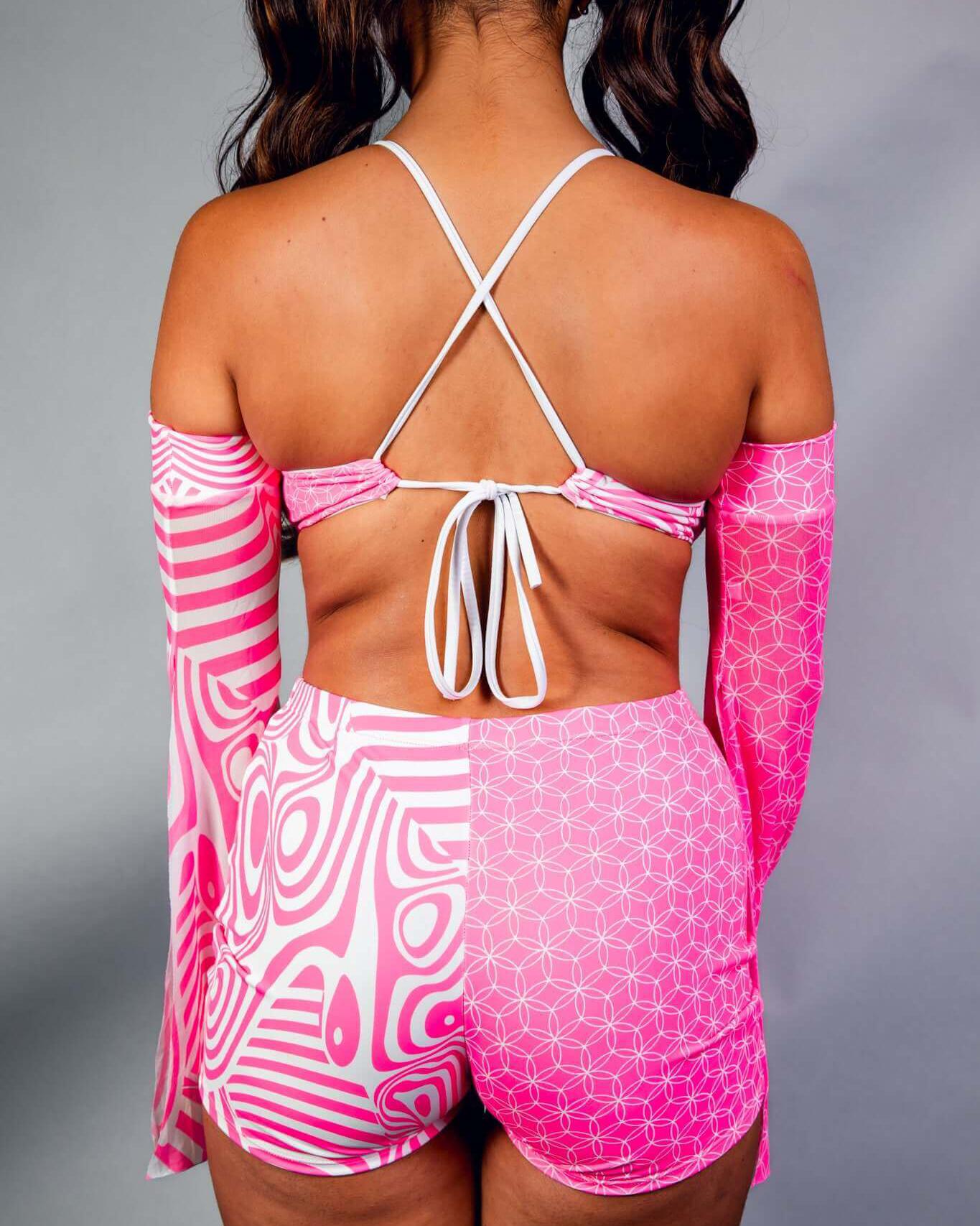 Woman from behind wearing a vibrant pink Electricity Serendipity Top with playful patterns, ideal for rave outfits.