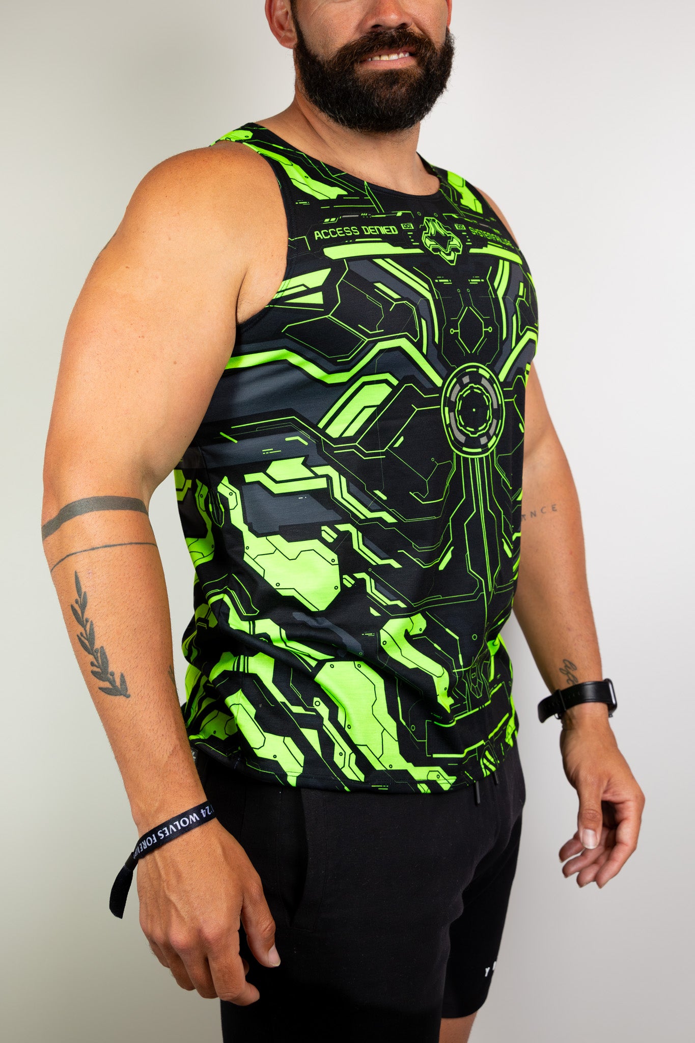  Model wearing a neon green and black tech-themed tank top, ideal for raves. Freedom Rave Wear provides unique festival fashion. 