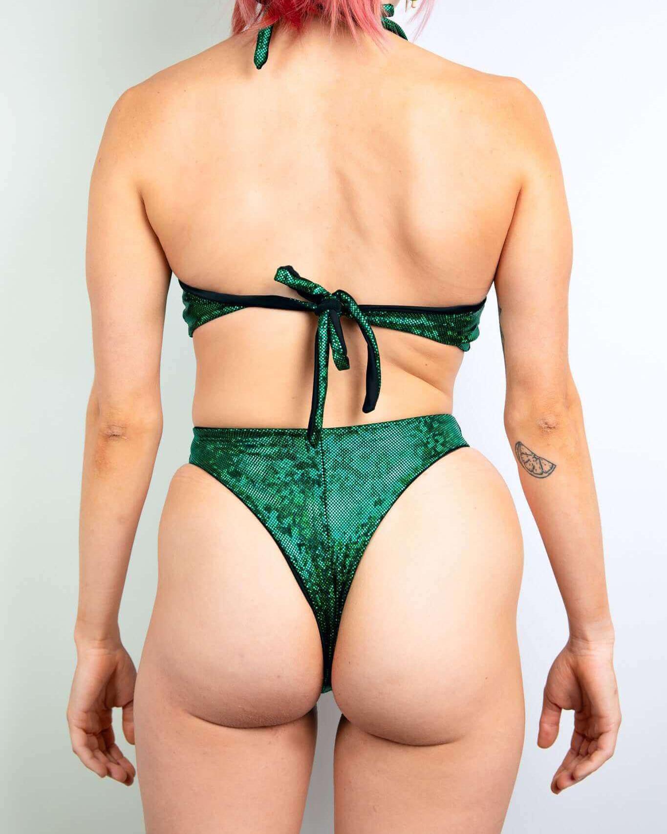 Back view of a woman in a green bikini showing chic tie design and cheeky cut, perfect for summer and beachwear.