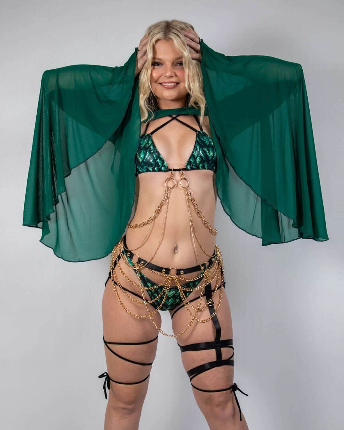 Model wearing emerald mesh bell sleeves with chain accessories, showcasing a stylish rave outfit.