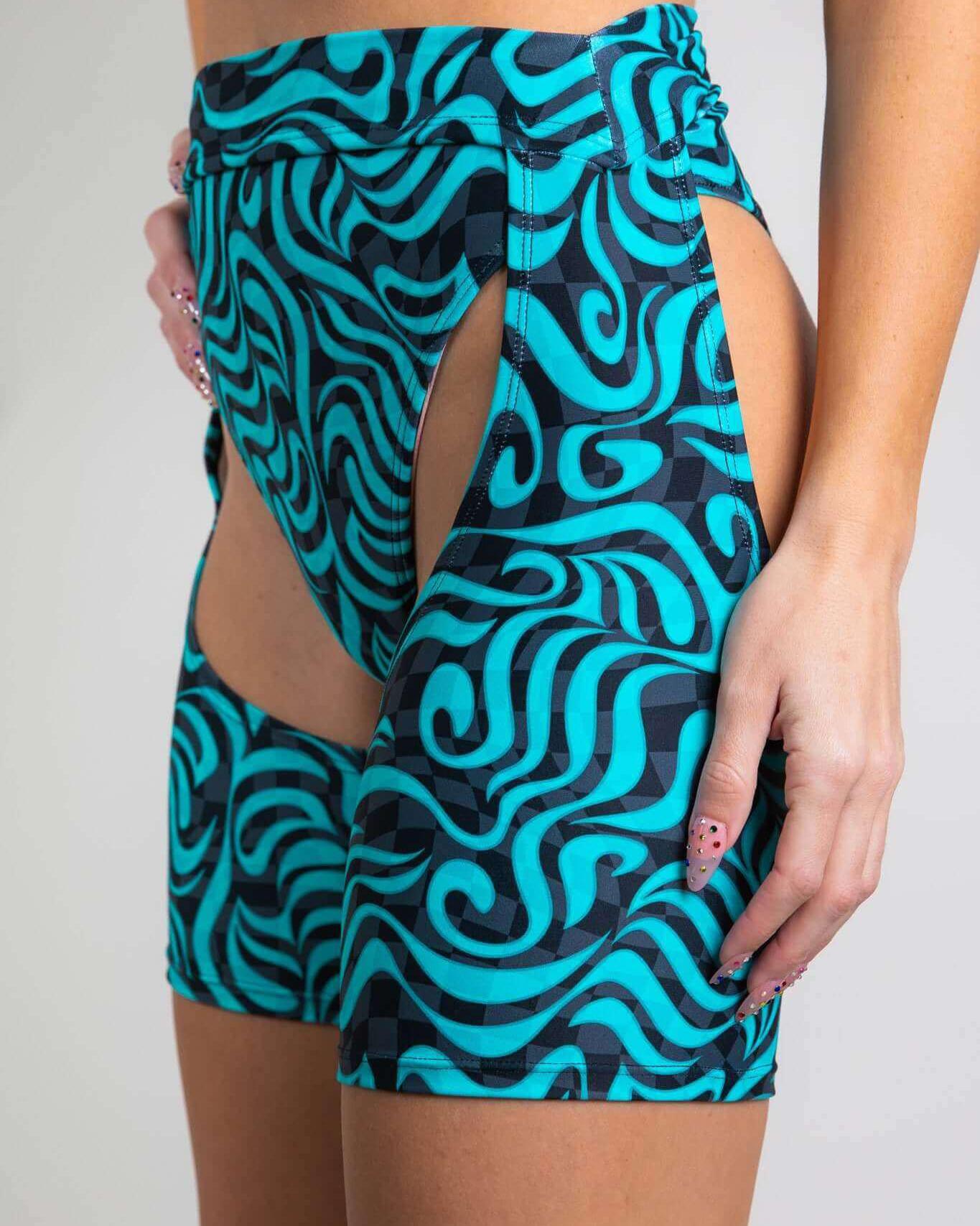 Enigma Chaps in vibrant turquoise with cutout design, perfect for rave outfits and showcasing your style.