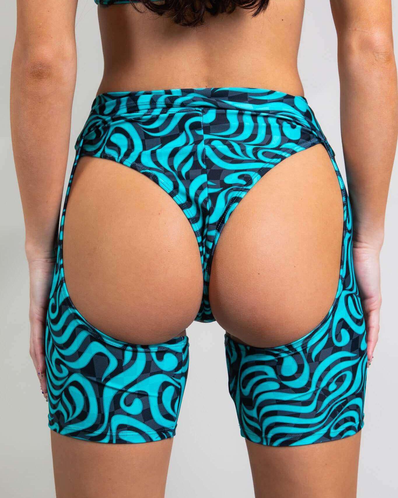 Enigma Chaps in vibrant swirls, showcasing a high waist cutout design, perfect for rave outfits and extreme lift.