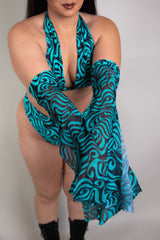 An up close photo of a woman's arms, wearing half bell sleeves in a blue and black swirl print.