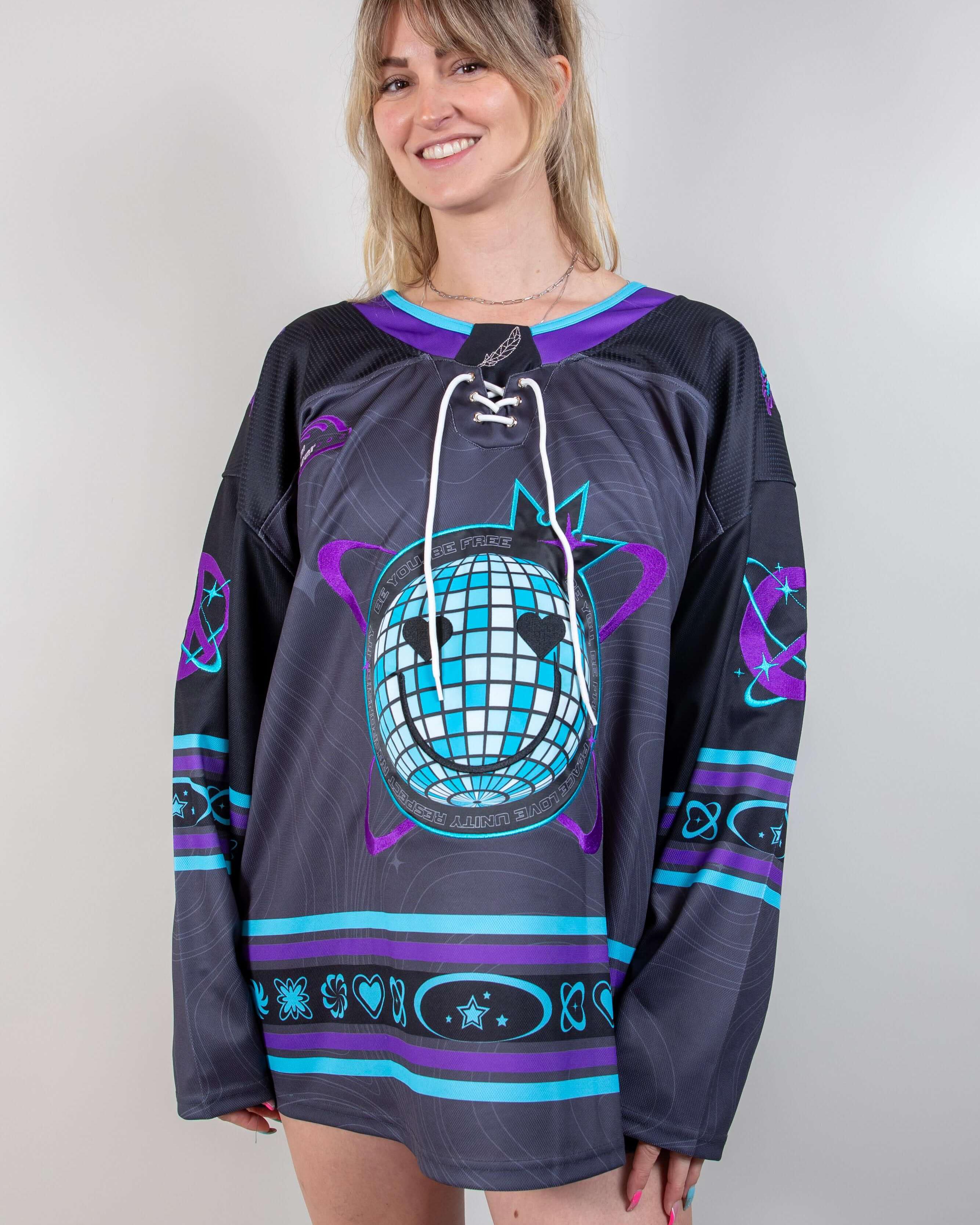 Woman modeling the Freedom Fam limited edition hockey jersey, featuring bold colors and rave-themed designs.