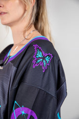 Close-up of the embroidered butterfly patch on the shoulder of the Freedom Fam hockey jersey, showcasing vibrant colors.