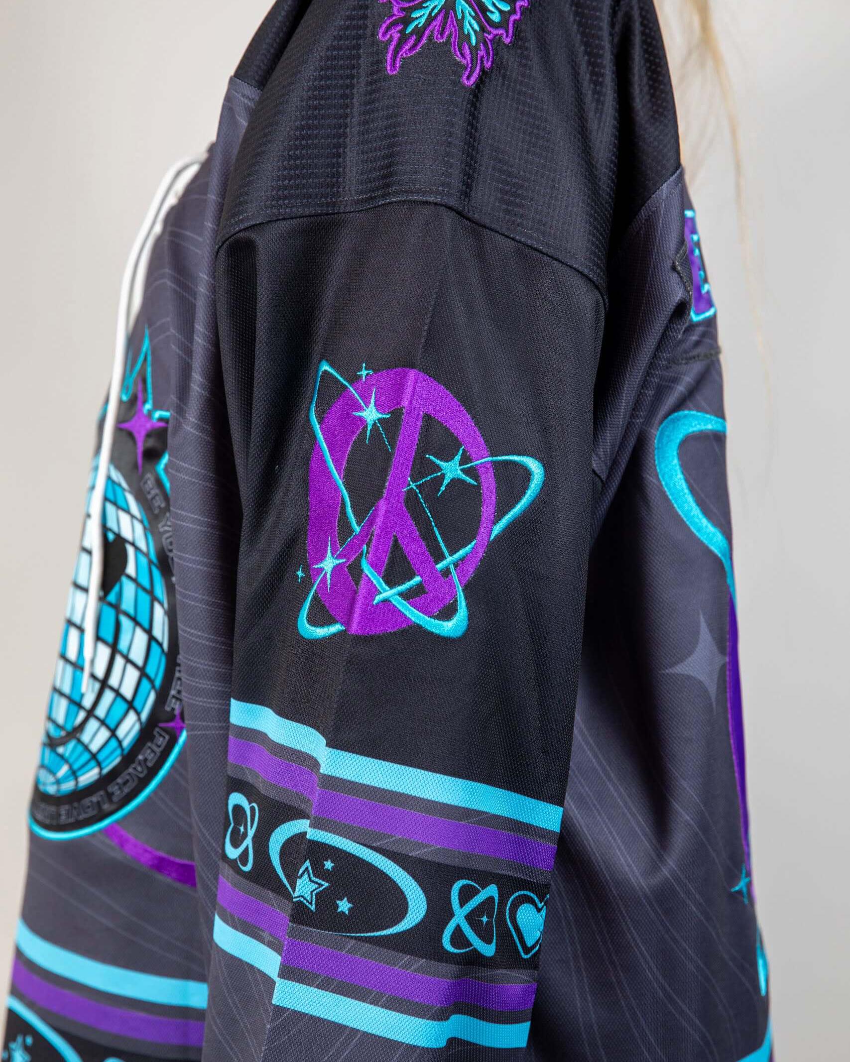 Detailed view of Freedom Fam hockey jersey featuring vibrant purple and blue designs, perfect for rave outfits.