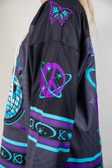 Detailed view of Freedom Fam hockey jersey featuring vibrant purple and blue designs, perfect for rave outfits.