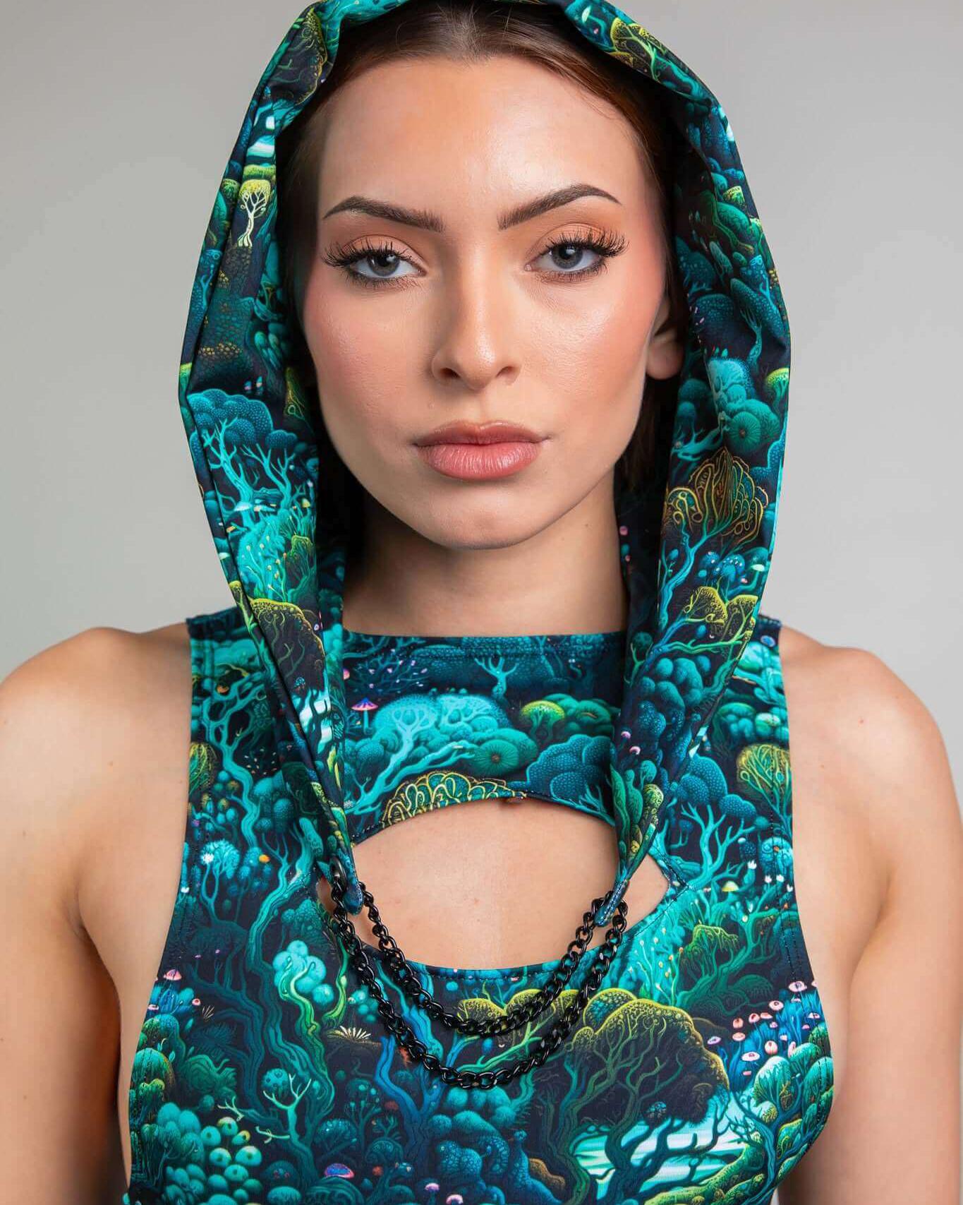 Model wearing Faewood Assassin Hood with vibrant forest pattern, showcasing a perfect rave outfit accessory.