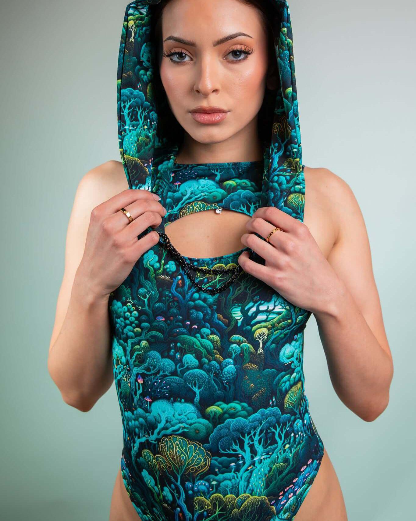 Model wearing Faewood Assassin Hood in vibrant forest print, showcasing a stylish festival accessory.