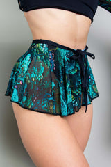 Close-up of a model in Freedom Rave Wear, featuring a high-waisted psychedelic print skirt with lace-up details, perfect for a stylish and vibrant rave appearance.