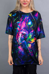 Close-up of a Freedom Rave Wear oversized tee with a vibrant fairy graphic in neon colors against a dark, enchanted forest backdrop