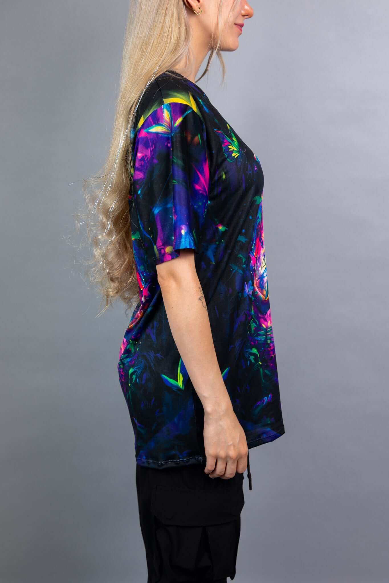 Side view of a Freedom Rave Wear oversized tee featuring a vivid fairy design with neon colors on a dark, mystical background.