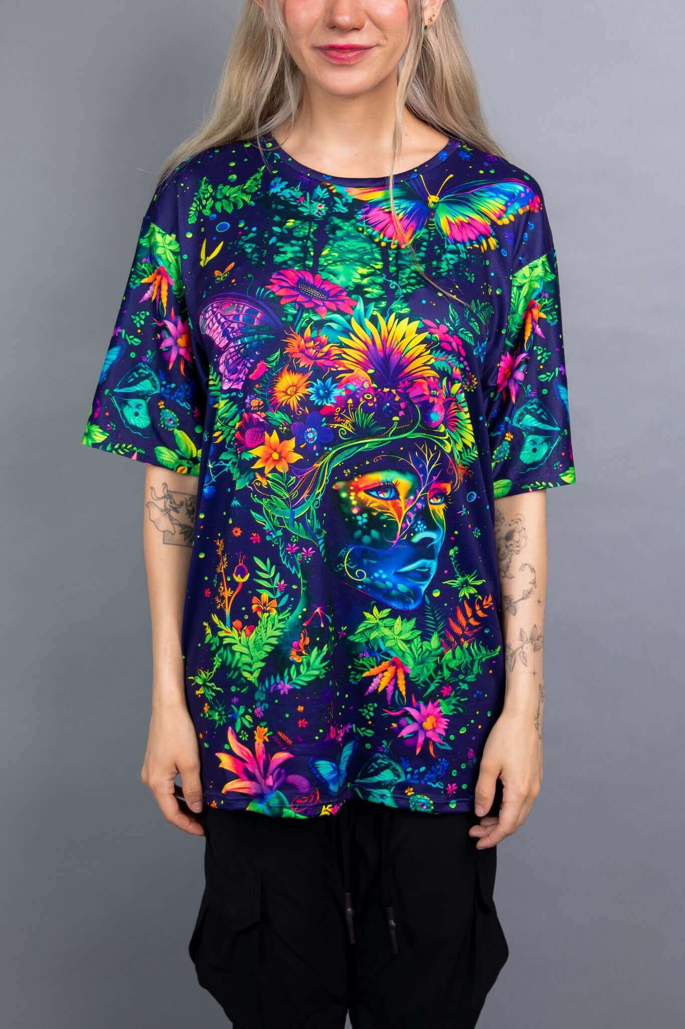 Model in a Freedom Rave Wear oversized tee featuring a vibrant design of a floral goddess with butterflies and lush foliage.