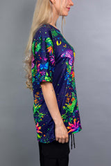 Side view of a model wearing a Freedom Rave Wear oversized tee featuring a vibrant floral goddess design with butterflies.