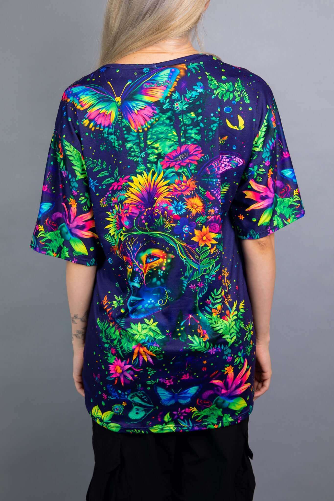 Back view of a Freedom Rave Wear oversized tee, showcasing a vibrant floral goddess design with butterflies on a dark background.