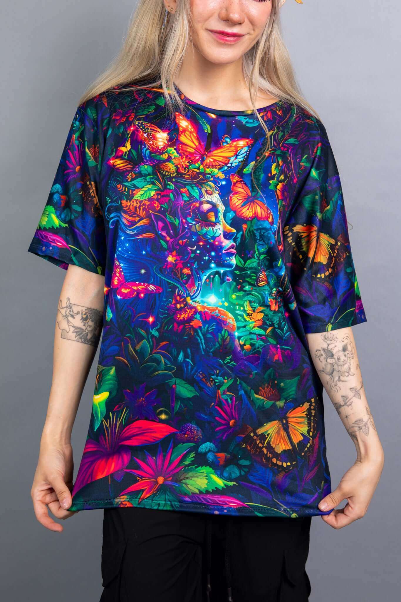 Close-up view of a Freedom Rave Wear oversized tee showcasing a vibrant, mystical design with butterflies and a nature-inspired fantasy scene.