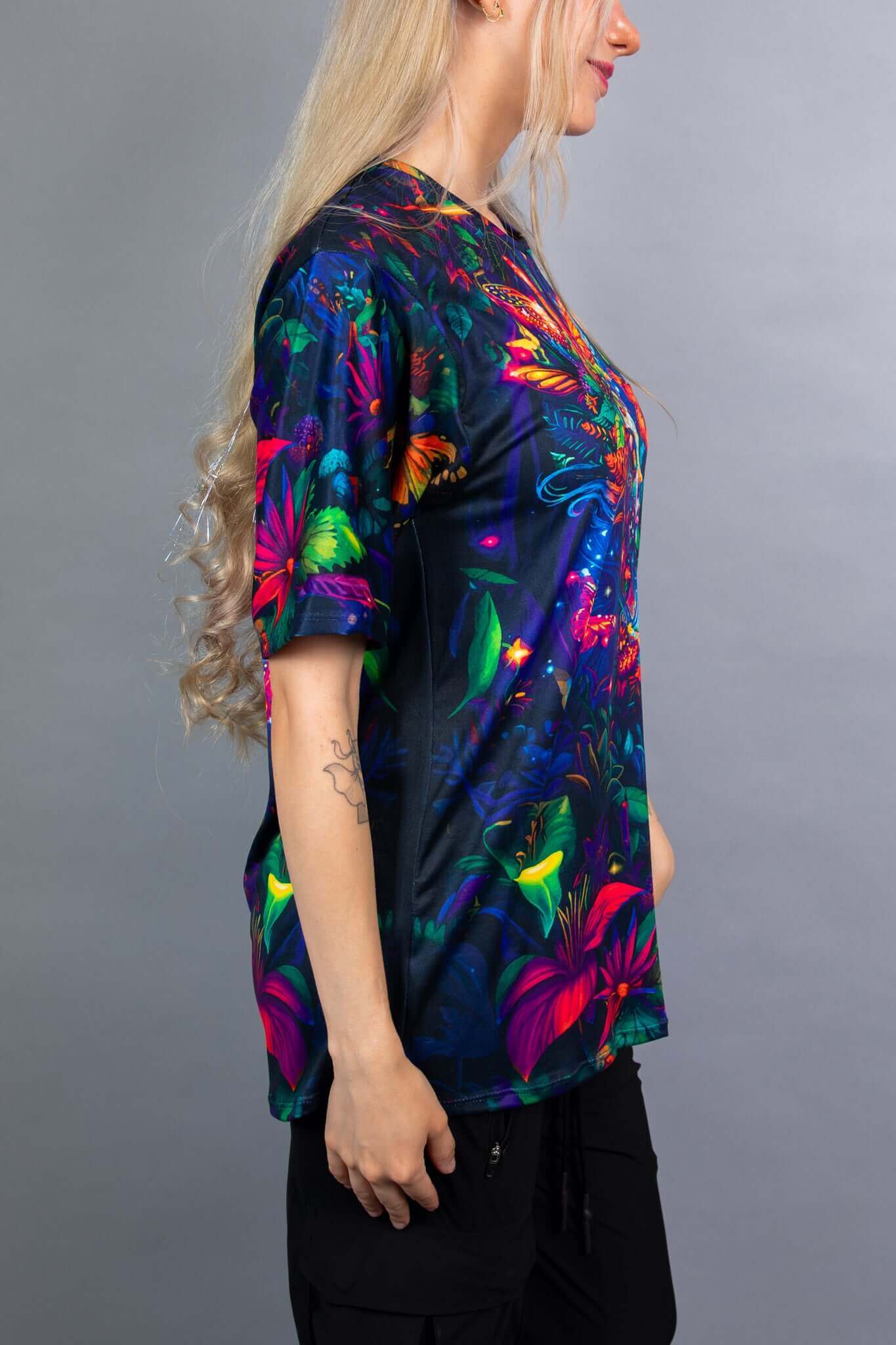 Side view of a Freedom Rave Wear oversized tee featuring a vibrant, nature-inspired fantasy design with colorful butterflies and foliage.