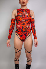 Model in a vibrant red and black Freedom Rave Wear bodysuit, featuring flame-inspired patterns and cut-out sleeves.