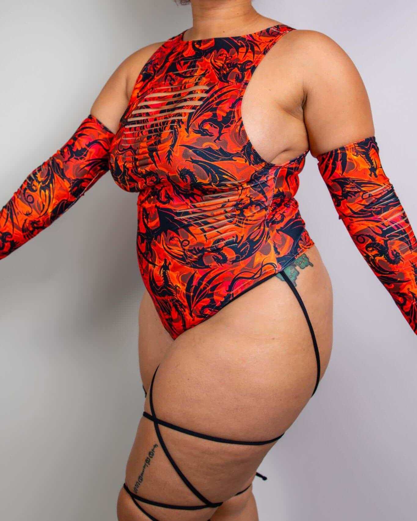 Model wearing Forbidden Slit Sideboob Bodysuit with leg straps, perfect for raves and showcasing bold, fiery print.