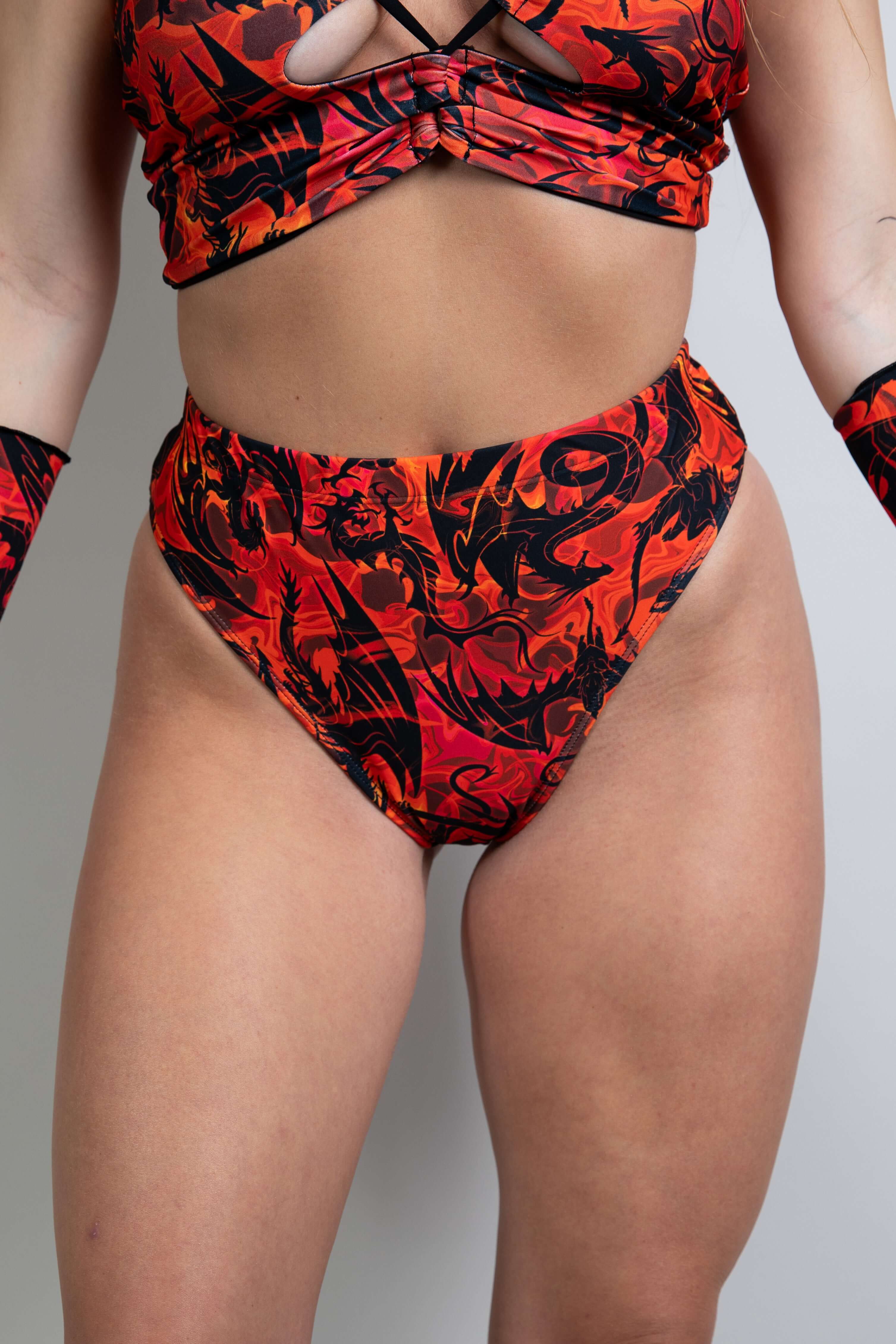 Close-up of Forbidden High Waisted Brazilian Bottoms, featuring a red and black magma print with a high-rise fit and cheeky Brazilian cut.