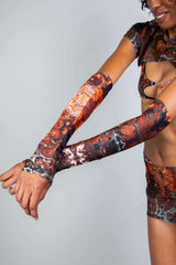 Model showcasing Fossil Arm Sleeves, perfect for rave outfits, featuring colorful, stretchy fabric that hugs the arms.