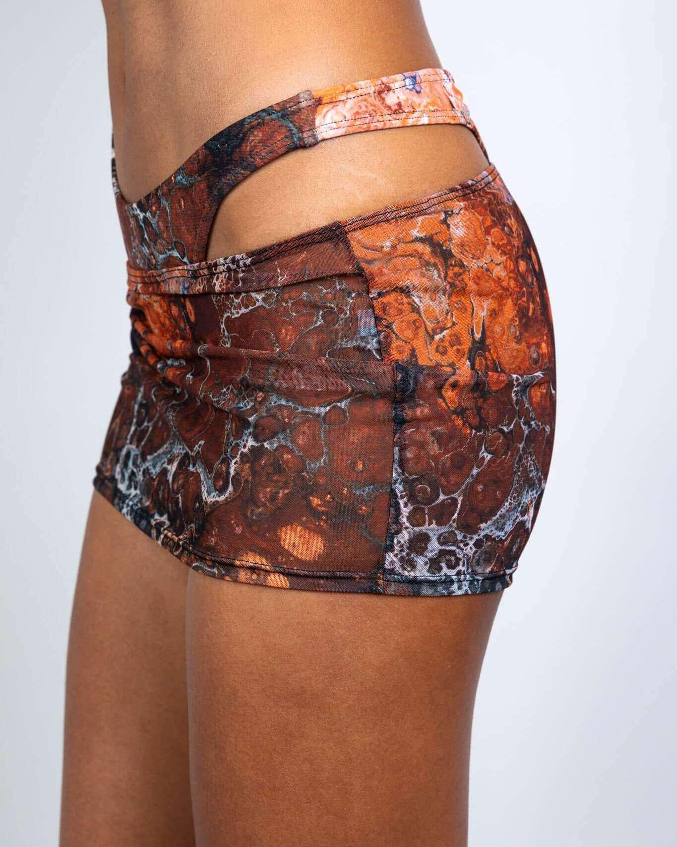 Side view of the Fossil Mesh Cinch Skirt featuring a stylish brown and orange pattern, ideal for rave outfits.