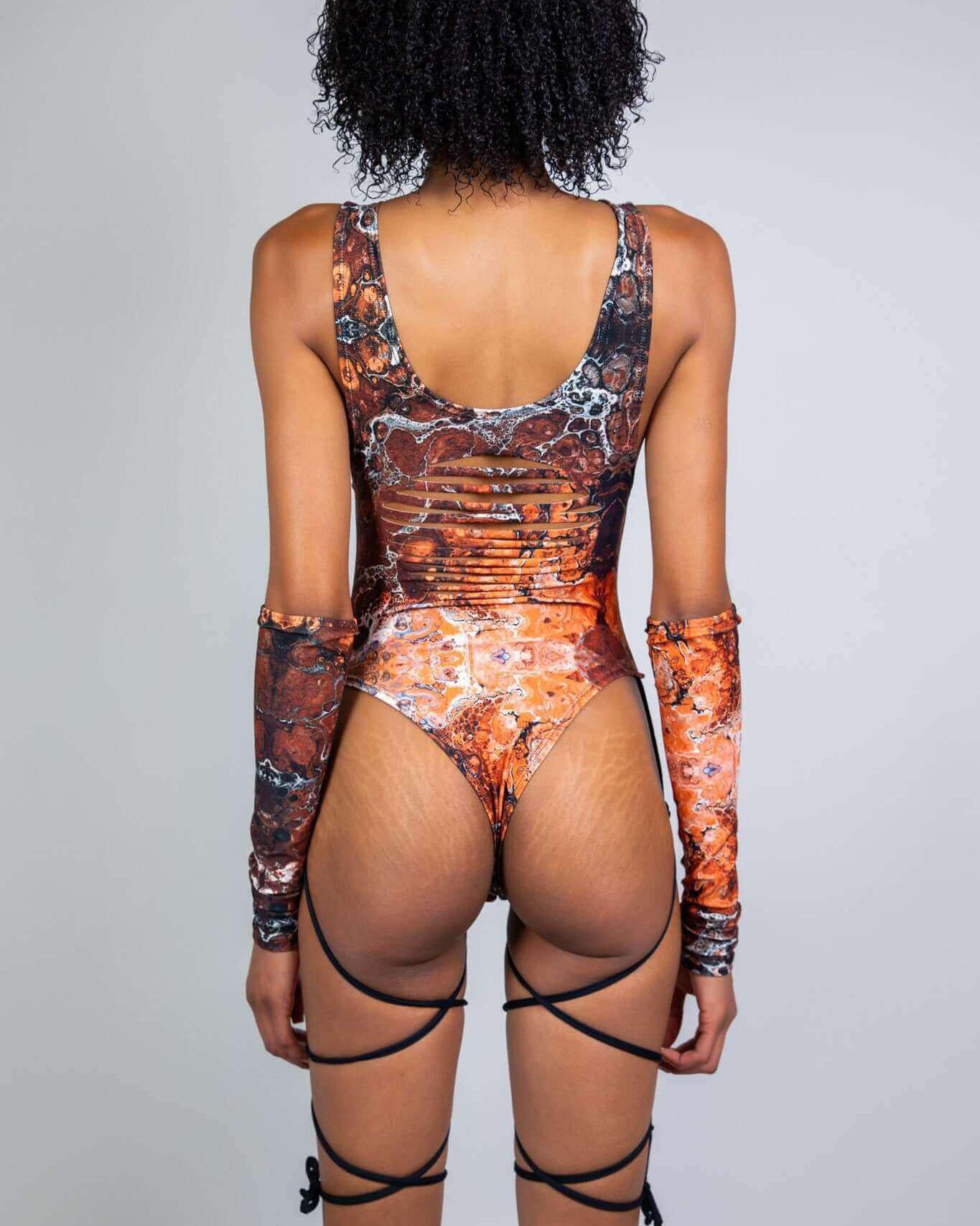 Back view of a model wearing the Fossil Slit Sideboob Bodysuit with fossil pattern and precut slits for customization.