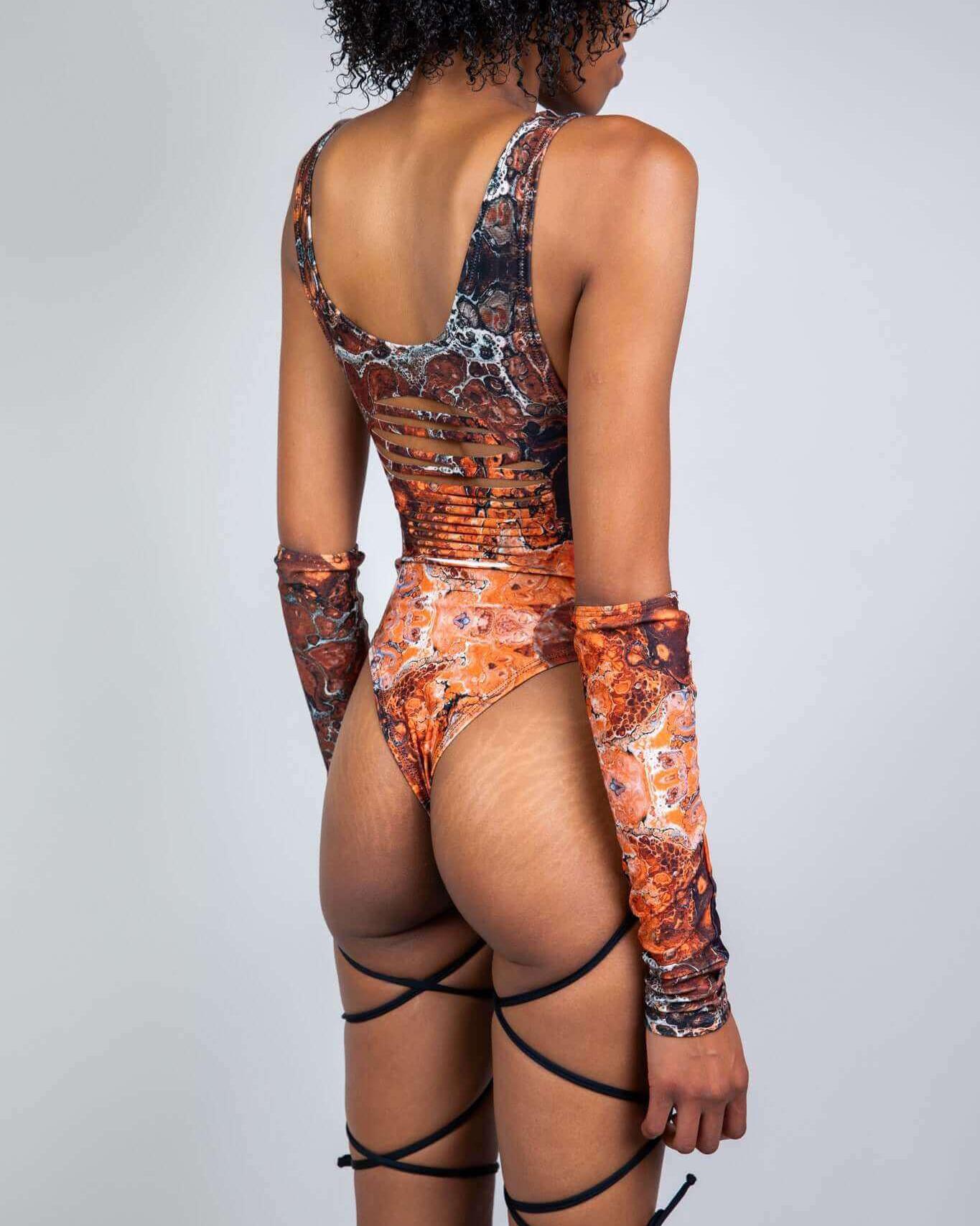 Model showcasing the Fossil Slit Sideboob Bodysuit with precut slits and unique fossil pattern, perfect for rave outfits.