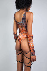 Side view of a model in a marbled brown and orange cut-out rave bodysuit with string details, designed by Freedom Rave Wear.