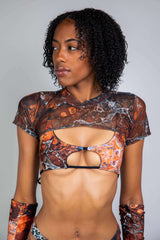 Model wearing the Fossil Mesh Strobe Top, featuring a marbled mesh design, perfect for rave outfits and confident style.