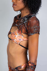 Model showcasing the Fossil Mesh Strobe Top, featuring a marbled pattern, perfect for rave outfits and stylish events.