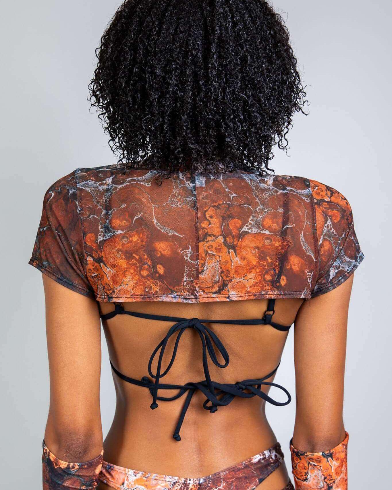 Back view of a model in a marbled mesh crop top, showcasing its unique design, perfect for rave outfits.