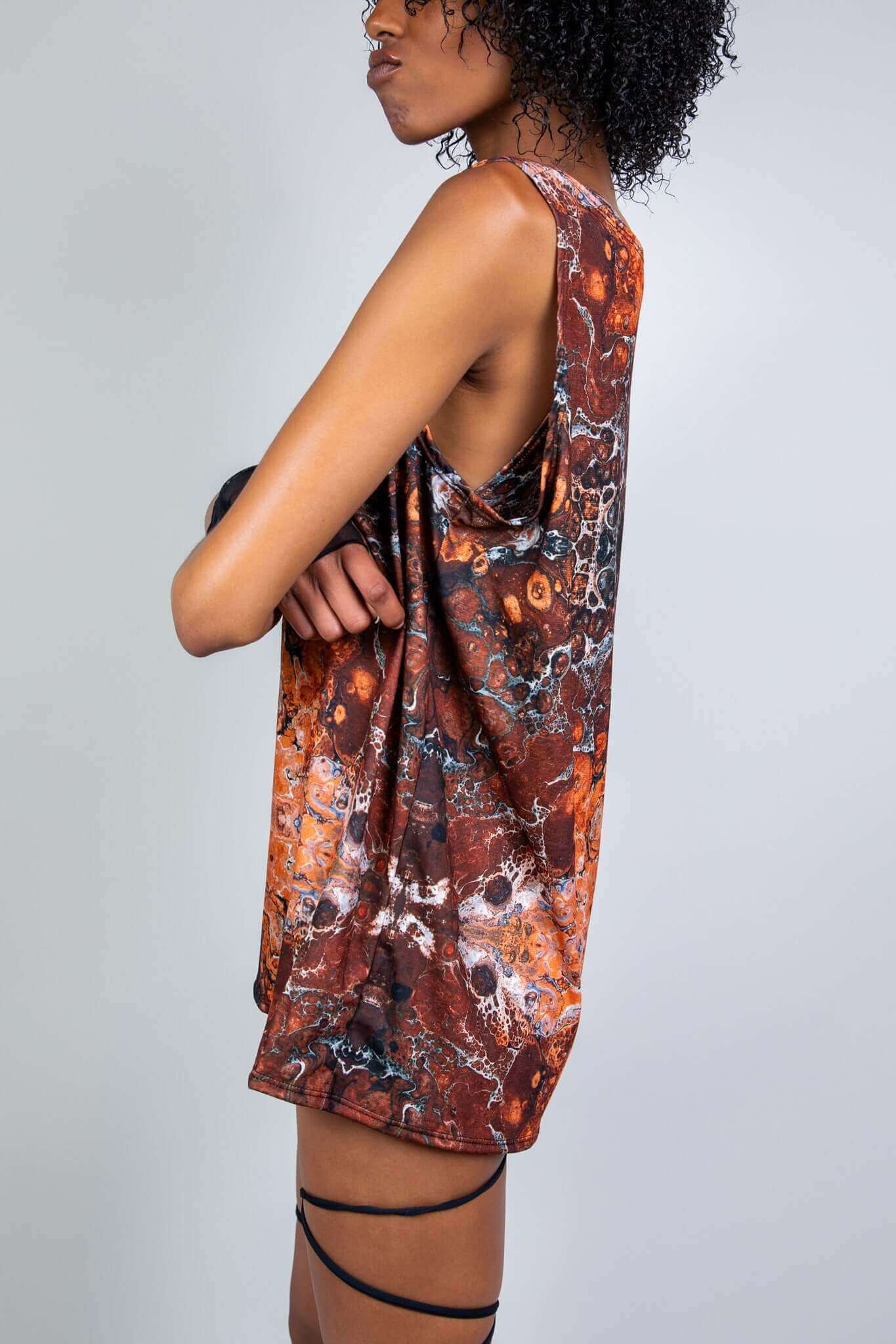 Model in a sleeveless rave tank with abstract patterns, side view, designed by Freedom Rave Wear with natural looks