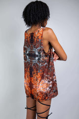 Model in a sleeveless, marbled brown and orange rave tank with abstract patterns, side view, designed by Freedom Rave Wear.