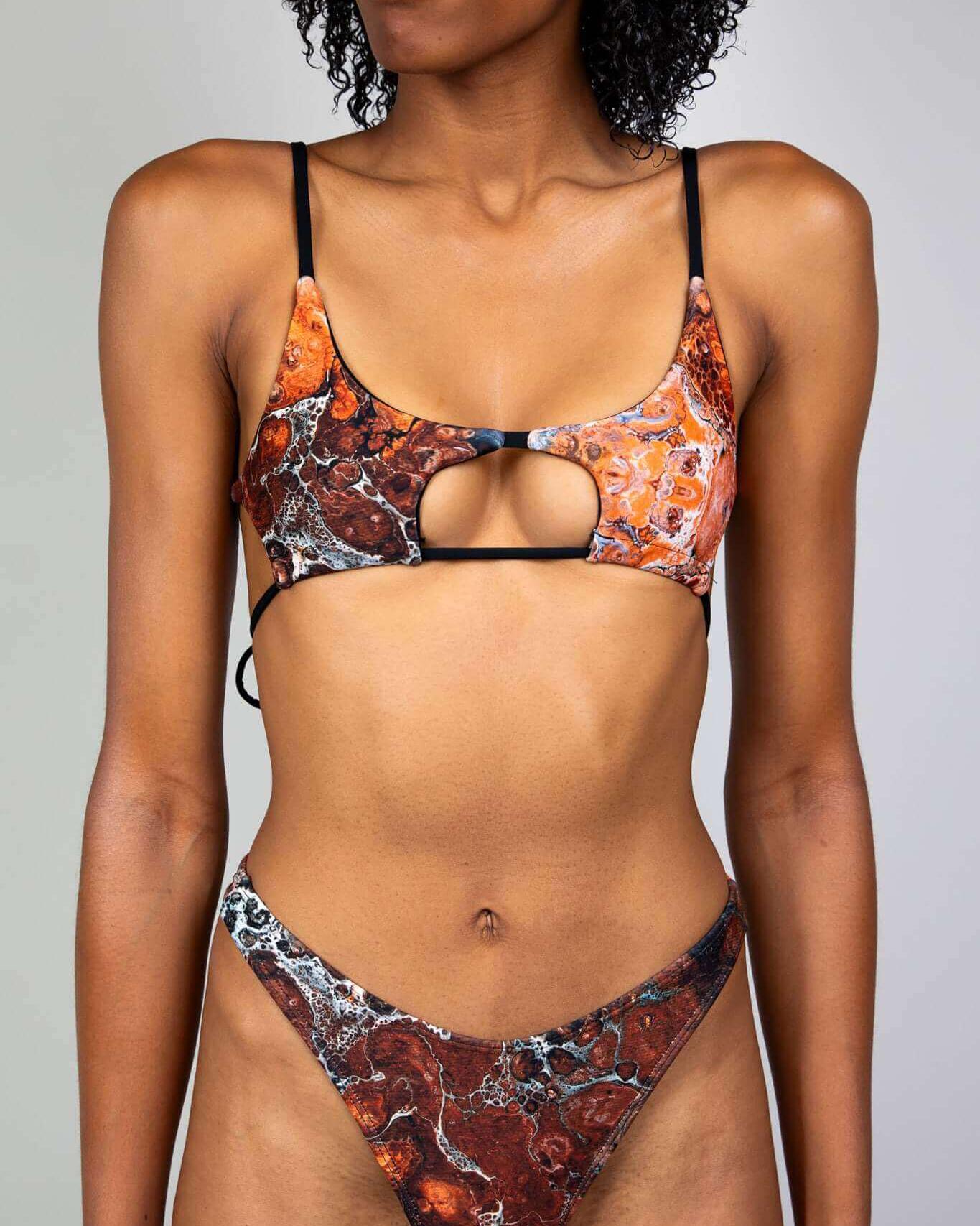 Model wearing a trendy two-piece swimsuit with a unique fossil-inspired print and cut-out detail.